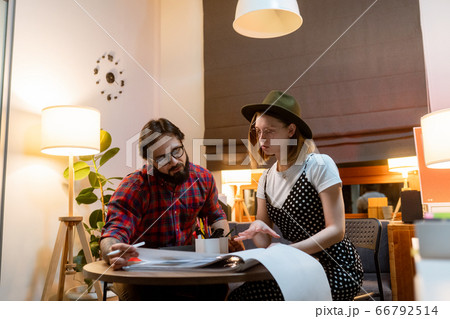 a group of young designers gathered in the evening in the office to discuss ideas 66792514