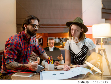 a group of young designers gathered in the evening in the office to discuss ideas 66792515
