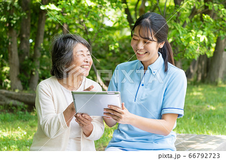 タブレットを操作するシニア女性と介護士 タブレットを操作するシニア女性と介護士 66792723