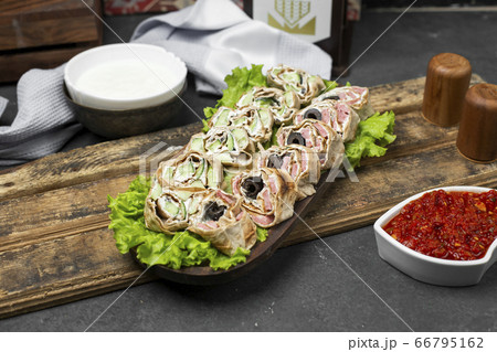 Roll salad in lavash bread on a lettuce leaf served with tomato paste Roll salad in lavash bread on a lettuce leaf served with tomato paste 66795162