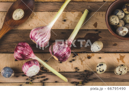 Quail eggs with garlic gloves on a wooden board 66795490