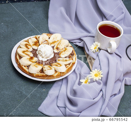 Waffles with banana, whipped cream and caramel sauce 66795542