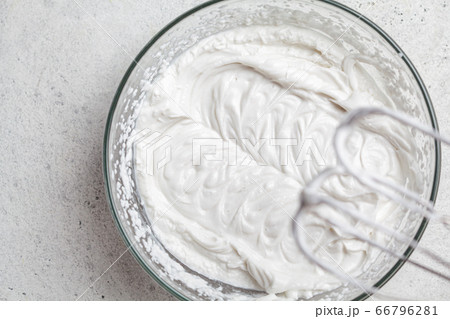 Cooking cream for cake in glass bowl and mixer. 66796281