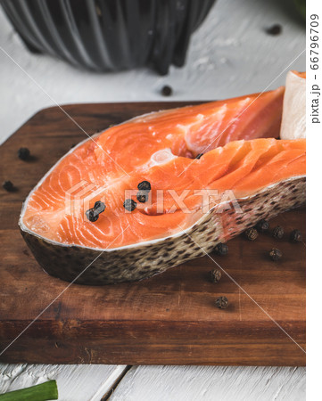 Salmon slices with black pepper balls on a wooden board 66796709