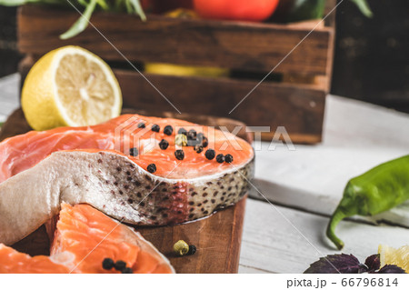 Salmon fillet slice with pepper and lemon on a white table 66796814