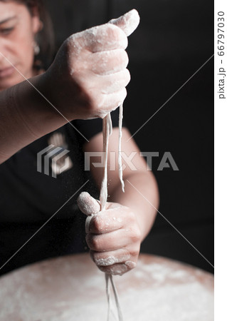 A cook cutting homemade spaghetti with hands 66797030