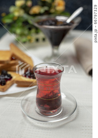 Toast slices with red jam and a glass of tea  66797329