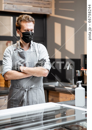 Salesman in protective wear in the cafe during a pandemic 66798244