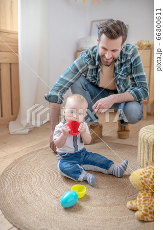 Father in a checkered shirt sitting near his little son 66800611