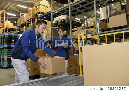 倉庫内のローラーコンベアに荷物を乗せる作業員男性 倉庫内のローラーコンベアに荷物を乗せる作業員男性 66801287