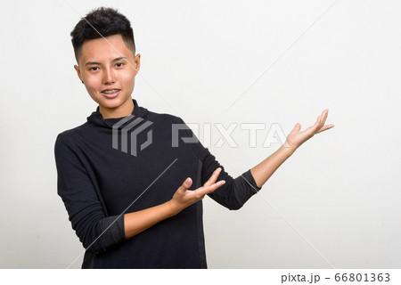 Portrait of happy young Asian lesbian woman showing something Portrait of happy young Asian lesbian woman showing something 66801363