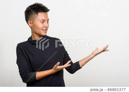 Portrait of happy young Asian lesbian woman showing something Portrait of happy young Asian lesbian woman showing something 66801377