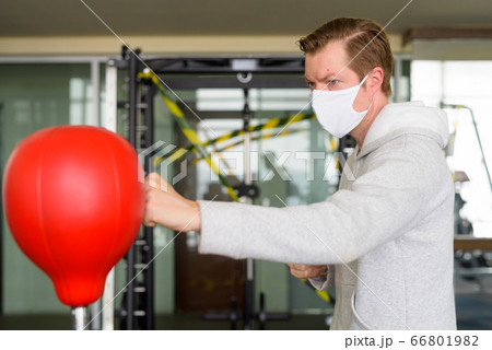 Young man wearing mask and boxing at the gym 66801982