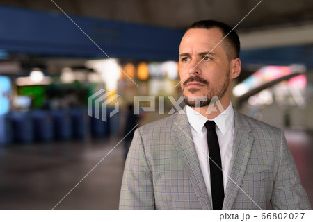 Handsome Hispanic bald bearded businessman walking off at the sky train station 66802027