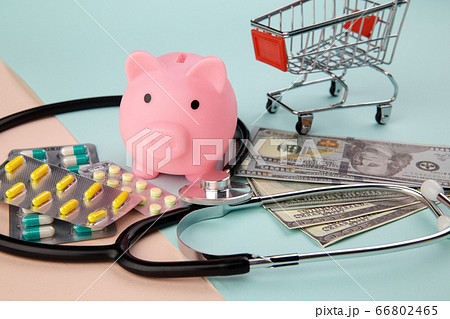 Health care cost concept. Stethoscope and drugs, piggy bank and dollars money banknotes on colorful background 66802465