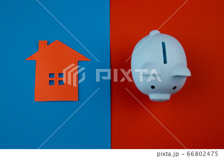 Mortgage concept. Little paper house next to a piggy bank on colorful background Mortgage concept. Little paper house next to a piggy bank on colorful background 66802475