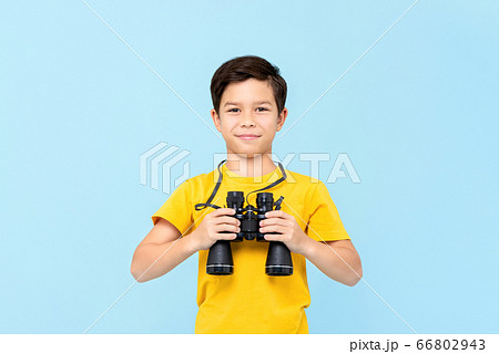 Portrait of smiling young boy holding binocular 66802943