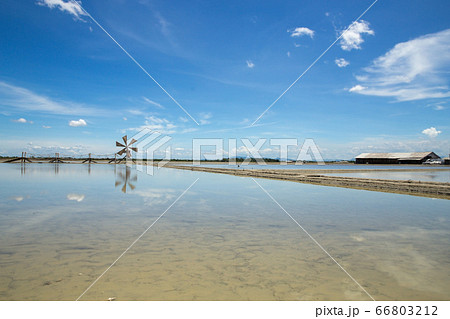 Wooden wind turbine in the salt field with blue 66803212