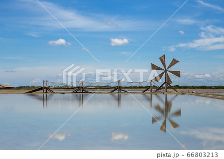 Wooden wind turbine in the salt field with blue 66803213