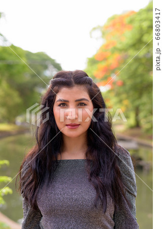 Face of young beautiful Indian woman at the park outdoors 66803417