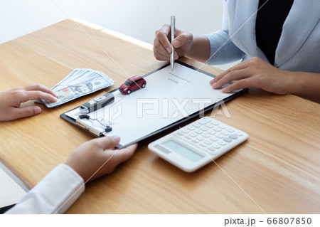 The car salesman handed the keys to the customer who passed the car purchase loan conditions ,Car rental agreement Concept. 66807850