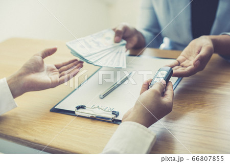 The car salesman handed the keys to the customer who passed the car purchase loan conditions ,Car rental agreement Concept. The car salesman handed the keys to the customer who passed the car purchase loan conditions ,Car rental agreement Concept. 66807855
