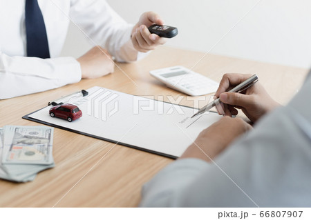 The car salesman handed the keys to the customer who passed the car purchase loan conditions ,Car rental agreement Concept. The car salesman handed the keys to the customer who passed the car purchase loan conditions ,Car rental agreement Concept. 66807907