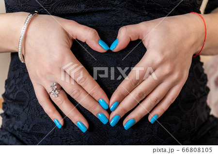 Russia, Saint Petersburg. The pregnant woman gently folded her hands like a heart on her tummy. 66808105