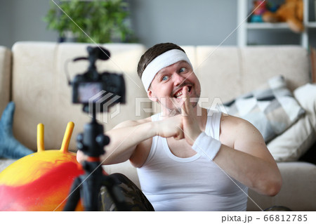 Cheerful man recording video during morning training Cheerful man recording video during morning training 66812785