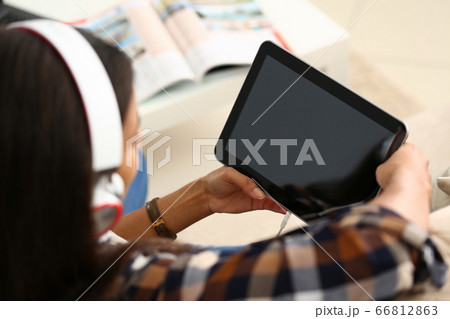 Young woman in headphones using tablet computer 66812863