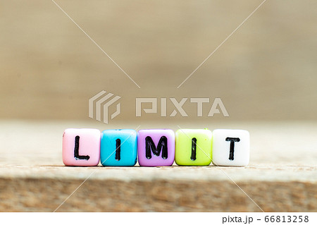 Colorful bead with black letter in word limit on wood background 66813258