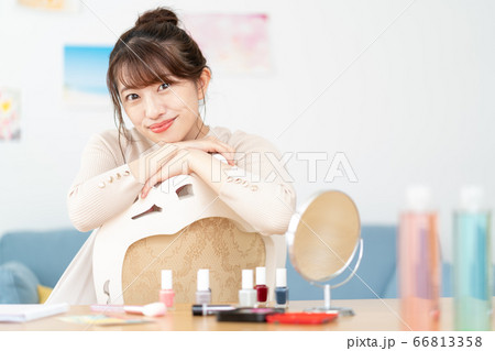 自宅のリビングでカメラ目線で微笑む若い女性のポートレート 自宅のリビングでカメラ目線で微笑む若い女性のポートレート 66813358