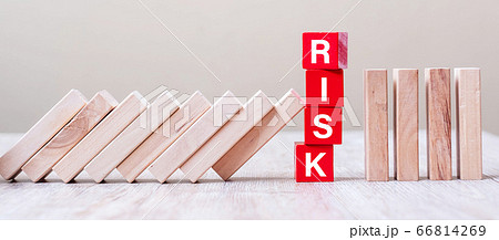 Red RISK cube blocks stop falling blocks on table. 66814269