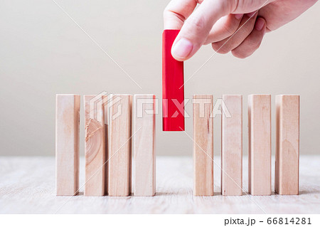 Businessman hand placing or pulling Red wooden Businessman hand placing or pulling Red wooden 66814281