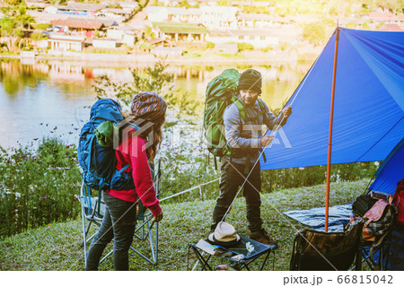 Couple Enjoying Camping Holiday in Countryside. Camp in the mountains near of the lake 66815042