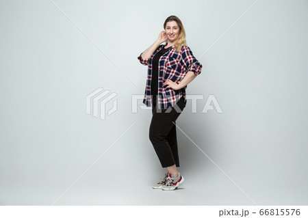 Young caucasian woman in casual wear on gray background. Bodypositive female character, plus size businesswoman 66815576