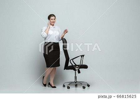 Young caucasian woman in office attire on gray background. Bodypositive female character. plus size businesswoman 66815625