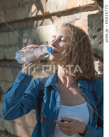 Female drinking bottle of water on a hot day 66816775