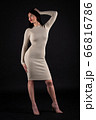 Woman in beige tight dress on black 66816786
