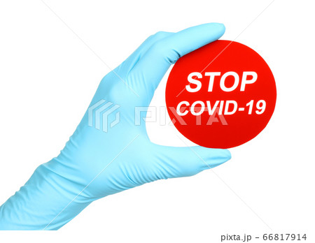 Woman hand in medical gloves holds red sign Stop 66817914