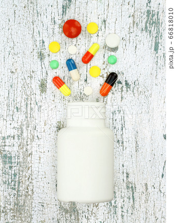 Color pills in the shape of heart on old wooden 66818010