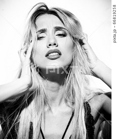emotions and feelings concept - beautiful blond lady portrait in sexy lingerie while getting an orgasm on white background. Woman shouts in ecstasy in bright light in monocrome 66819258