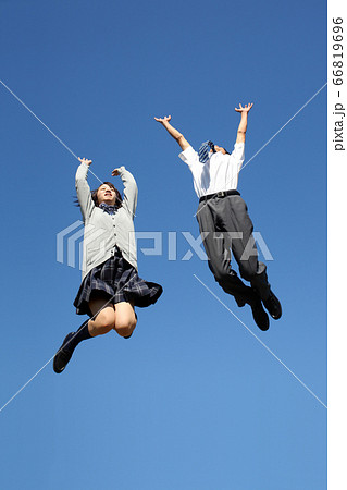 青空を背景に万歳をしながらジャンプする男女高校生2人。 66819696