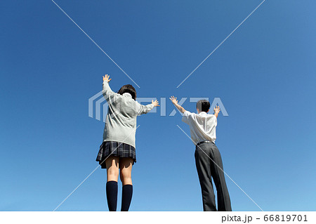 青空に向かい万歳を一緒にする高校生男女 66819701