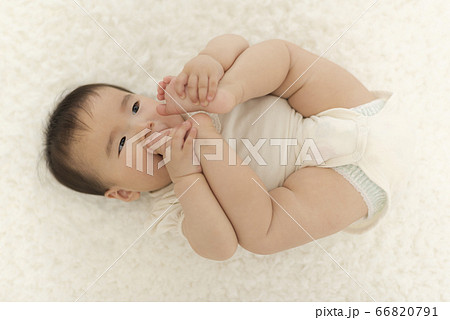 赤ちゃんが自分の足の指を舐めるの写真素材