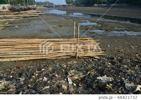 バングラデシュのコックスバザール　海岸沿いの漁村と停留中の漁船　砂浜に置かれた竹と散乱するゴミ 66821732