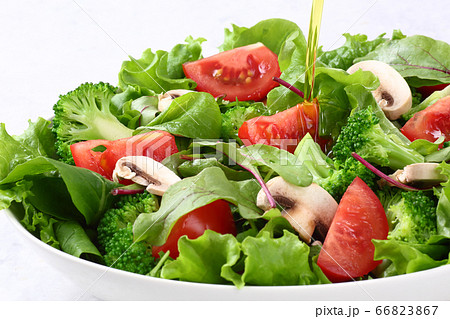 サラダにオリーブオイルをかける 66823867