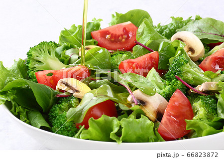 サラダにオリーブオイルをかける 66823872