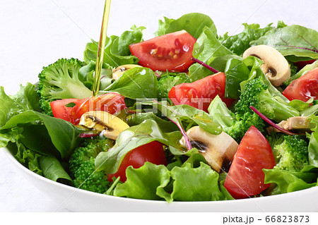 サラダにオリーブオイルをかける サラダにオリーブオイルをかける 66823873