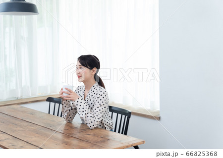 自宅でお茶を飲んでいる女性 66825368